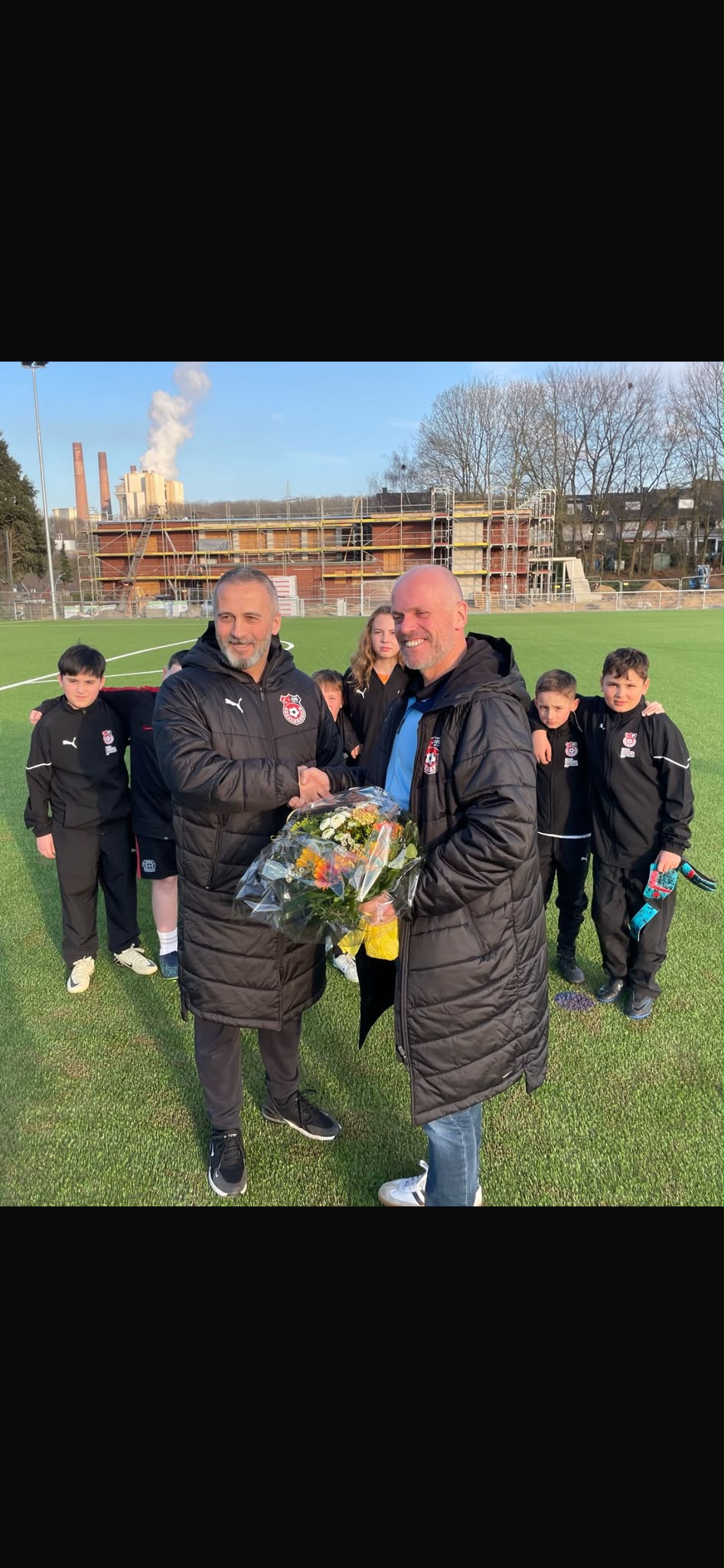 Gemeinsamer Moment auf dem Fußballplatz bei der Eröffnung der Sportanlage